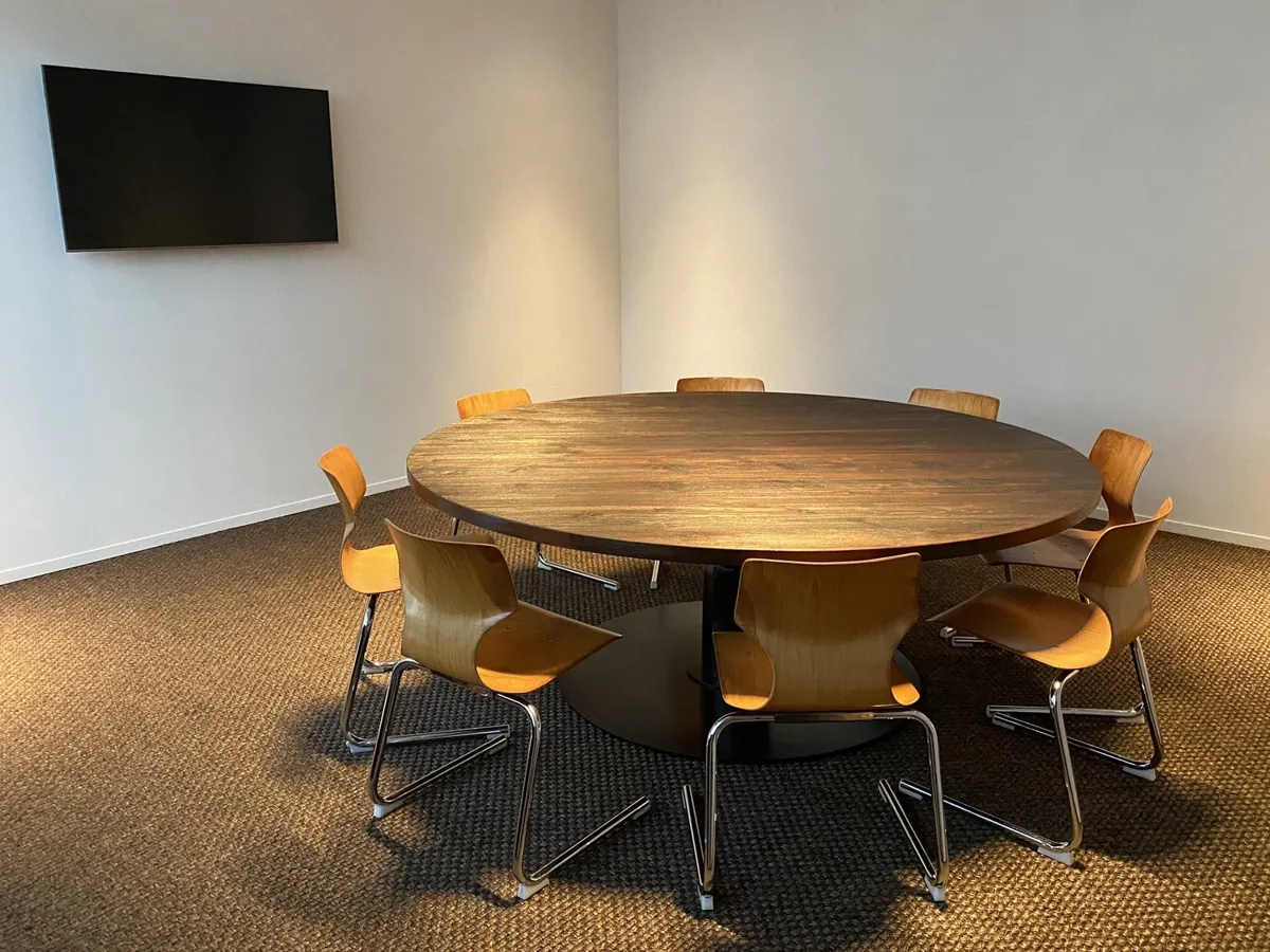 Meeting room with round wooden table in Cotton Factory